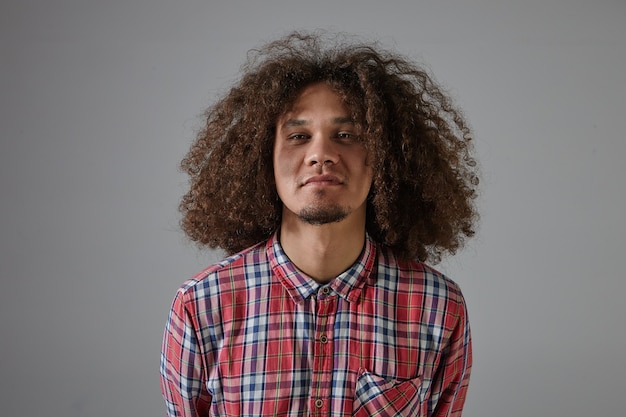 Concept de soins de personnes, de mode et de cheveux. Hipster barbu élégant horizontal guy portant anneau de nez et chemise à carreaux rouge shampooing publicitaire, ayant une coiffure volumineuse shaggy