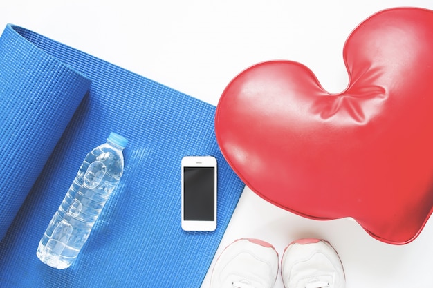 Concept de soins de santé avec des équipements de sport sur fond blanc avec smartphone, Flat Lay