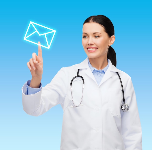 Concept de soins de santé, de médecine et de technologie - femme médecin souriante pointant vers l'enveloppe