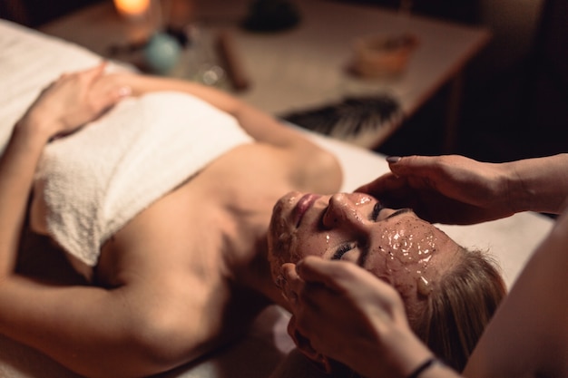 Concept de spa avec une femme avec de la crème au visage