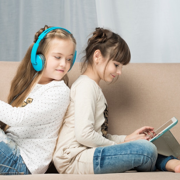 Concept de technologie avec deux filles sur le canapé