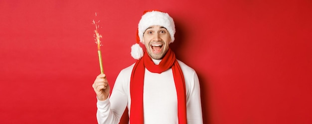 Photo gratuite concept de vacances d'hiver de noël et célébration bel homme célébrant le nouvel an et ayant fu