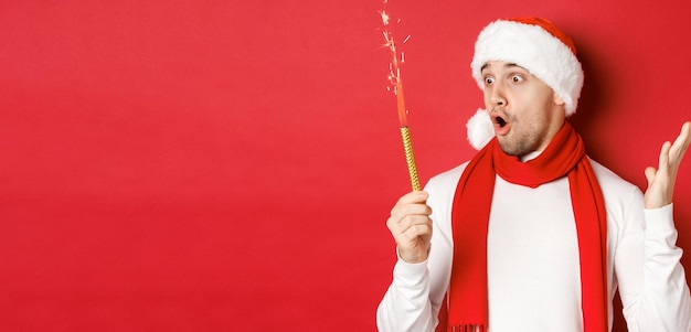 Concept de vacances d'hiver de Noël et de célébration en gros plan d'un bel homme étonné en bonnet de noel et...