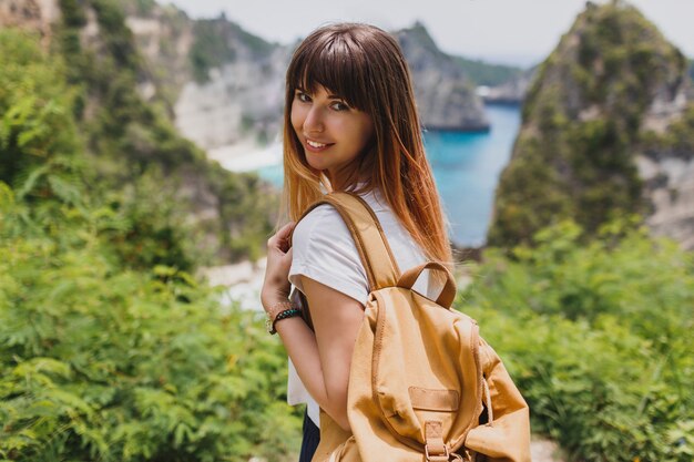 Concept de voyage et d'aventure. Femme heureuse avec sac à dos voyageant en Indonésie sur l'île de Nusa Penida.