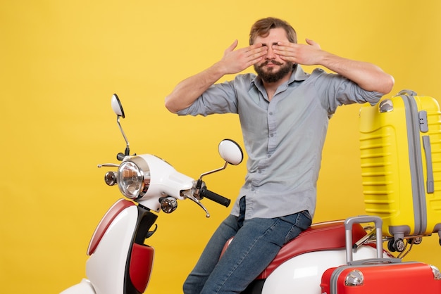 Concept de voyage avec jeune homme barbu assis sur une moto et fermant les yeux dessus sur jaune