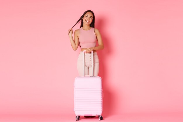 Concept de voyage, vacances et vacances. Toute la longueur de la coquette fille asiatique brune rêveuse en vêtements d'été