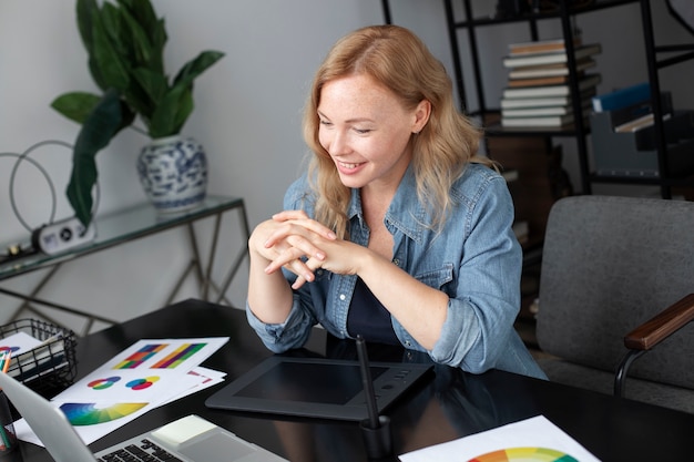 Conceptrice de logo féminin travaillant dans son bureau sur une tablette graphique