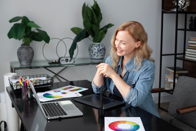 Photo gratuite conceptrice de logo féminin travaillant dans son bureau sur une tablette graphique