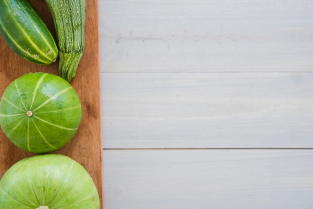 Concombre; courgettes et gourde sur planche à découper sur la table