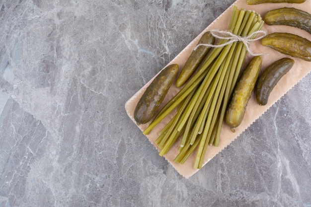 Photo gratuite concombres et haricots verts fermentés sur planche de bois.