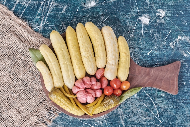 Photo gratuite concombres marinés, ail, poivrons et tomates sur plaque en bois.