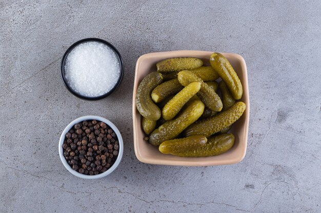 Concombres marinés dans des bols placés sur une table en pierre.