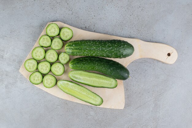 Concombres tranchés frais avec couteau sur une planche de bois. photo de haute qualité