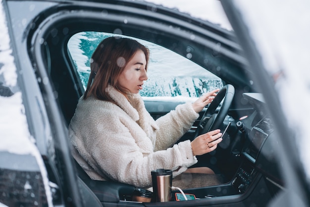 Conducteur de jolie femme assise derrière le volant dans sa voiture