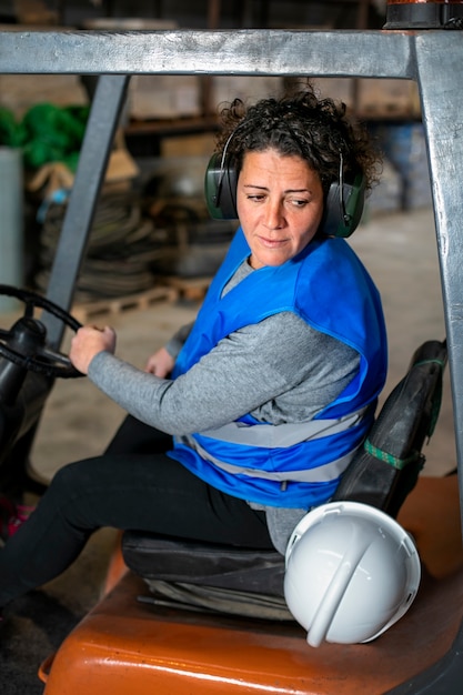 Photo gratuite conductrice professionnelle exploitant un véhicule de chariot élévateur