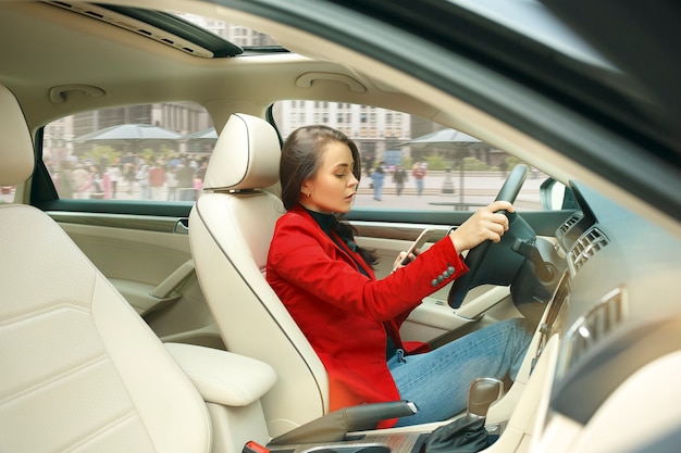 Conduire en ville. Jeune femme séduisante au volant d'une voiture.