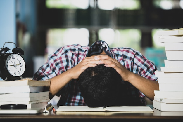 Photo gratuite conept éducatif: étudiant fatigué dans une bibliothèque