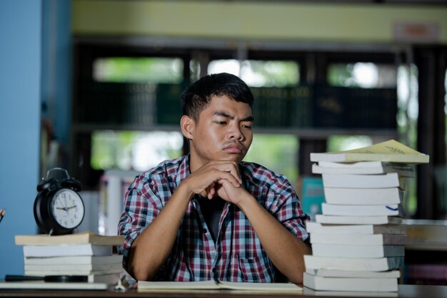 Conept éducatif: étudiant fatigué dans une bibliothèque