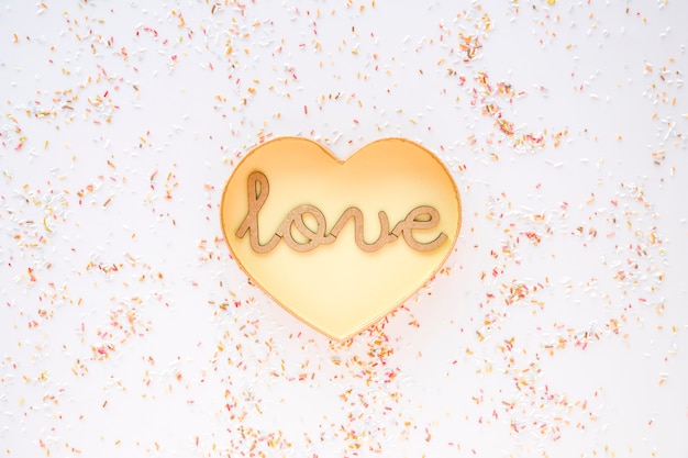 Photo gratuite confetti autour du coeur et amour d'écriture