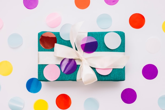 Un confetti coloré sur la boîte cadeau emballé isolé sur fond blanc