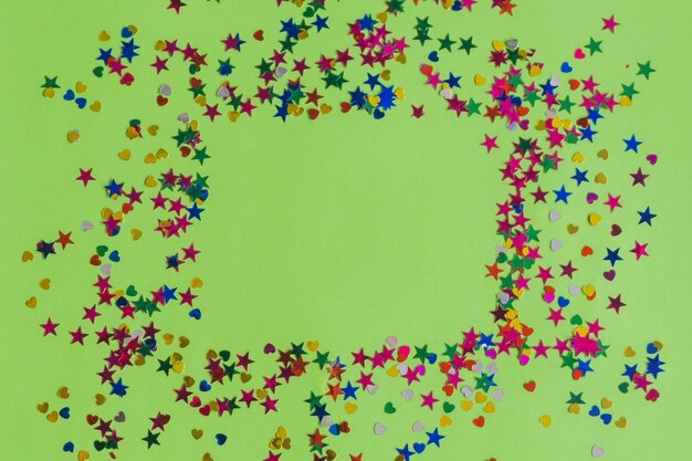 Confetti sur une table verte faisant un carré