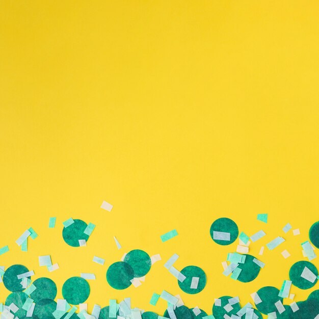 Confetti vert sur fond jaune avec espace de copie