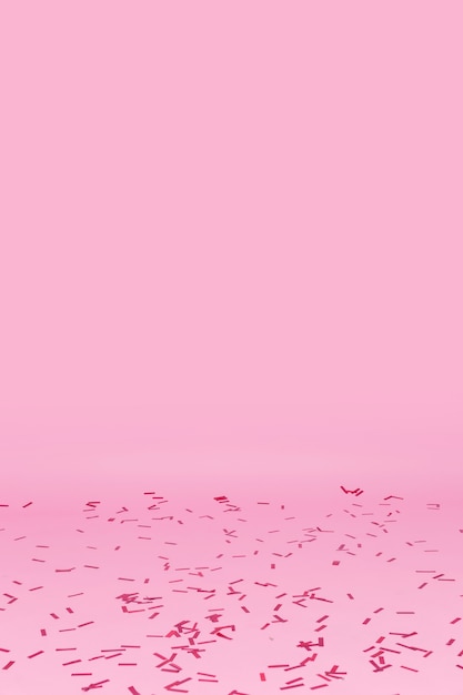 Photo gratuite confettis dispersés sur fond rose
