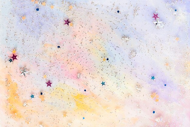 Confettis étoiles pailletées sur fond aquarelle pastel abstrait coloré