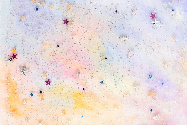 Confettis étoiles pailletées sur fond aquarelle pastel abstrait coloré