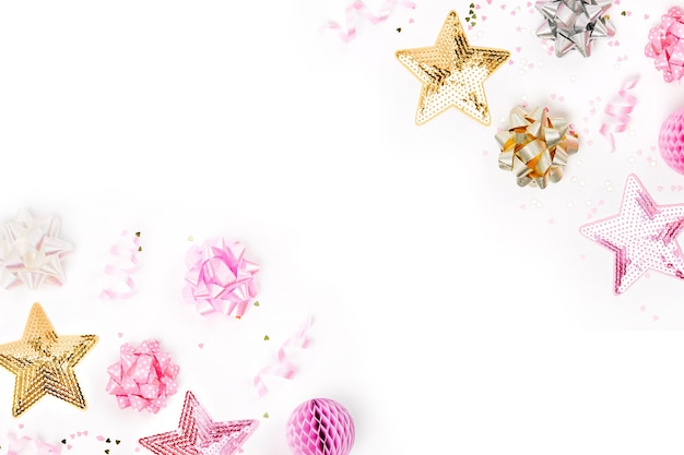 Confettis rose pastel, nœuds et décorations en papier. mise à plat, vue de dessus. composition de vacances pour fête d'anniversaire, célébration du nouvel an/noël ou thème de concept de fête de poule. mise à plat, vue de dessus