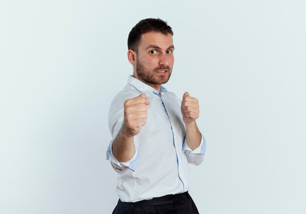 Confiant bel homme garde les poings prêts à frapper isolé sur mur blanc