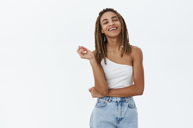 Confiant élégant fille afro-américaine croiser les bras et l'air heureux, souriant