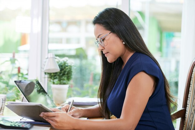 Confiant femme d'affaires travaillant avec tablette au bureau