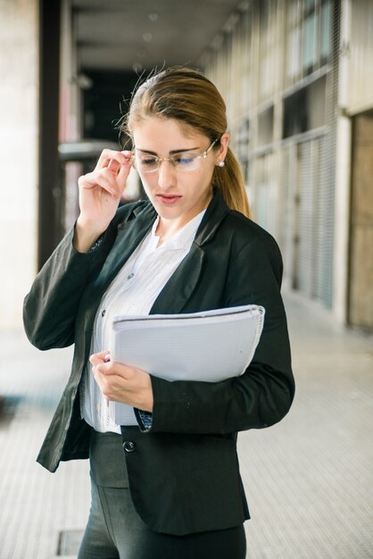 Confiant jeune femme tenant le document en main