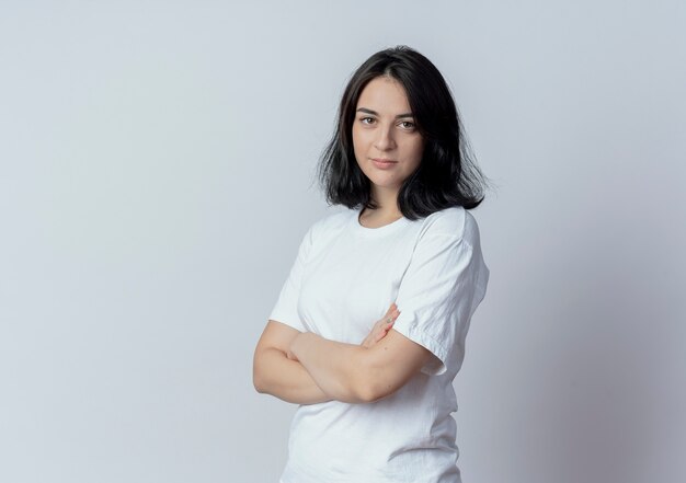 Confiant jeune jolie fille caucasienne debout avec une posture fermée en vue de profil isolé sur fond blanc avec espace de copie