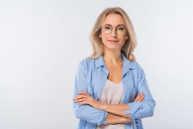 Photo gratuite confiante jeune femme blonde avec les bras croisés, debout sur un fond blanc