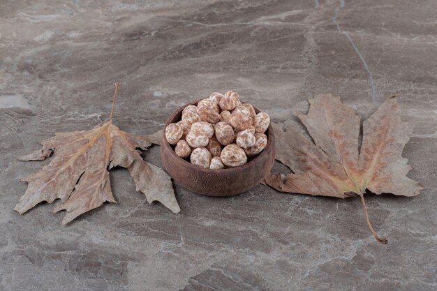 Confiserie savoureuse et feuilles sur la surface en marbre