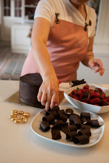 Confiseur féminin avec gâteau au chocolat dans la pâtisserie