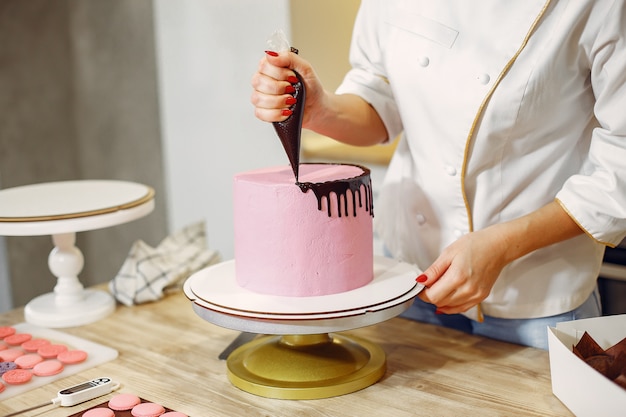 Confiseur en uniforme décore le gâteau