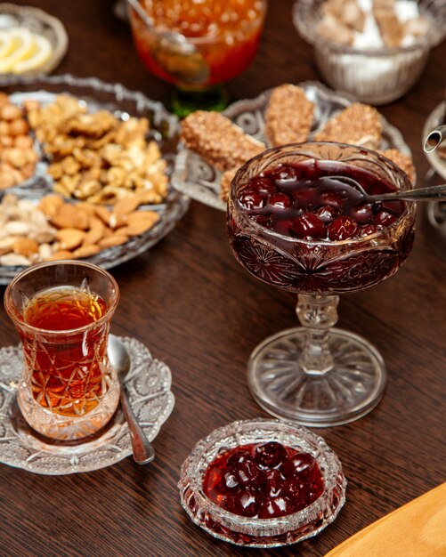 Confiture de cerises cornéliennes servie dans un plat en cristal avec du thé