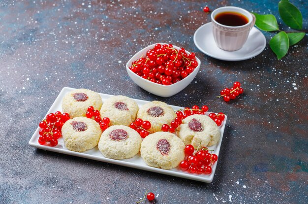 Confiture de groseille rustique rustique faite maison avec des biscuits à la noix de coco et une tasse de thé