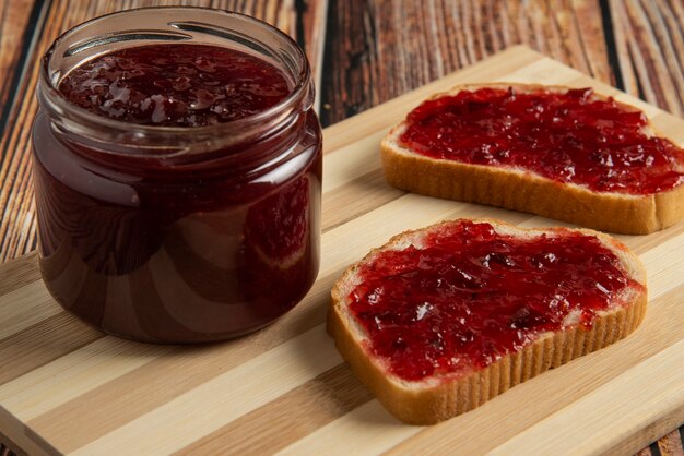 Confiture de prunes dans le bocal en verre et sur les toasts.