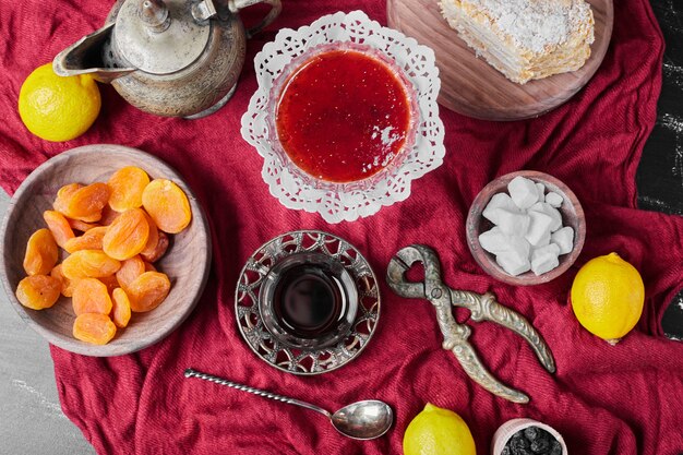 Confiture sur serviette rouge avec du thé.