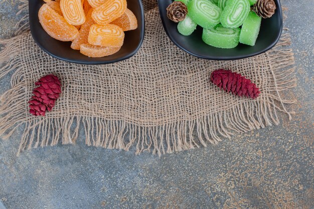 Photo gratuite confitures sucrées dans des assiettes sombres sur un sac. photo de haute qualité