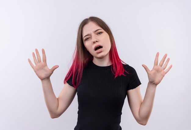 Confus belle jeune femme portant un t-shirt noir se propage les mains sur un mur blanc isolé