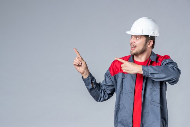 constructeur masculin vue de face en uniforme et casque sur fond gris