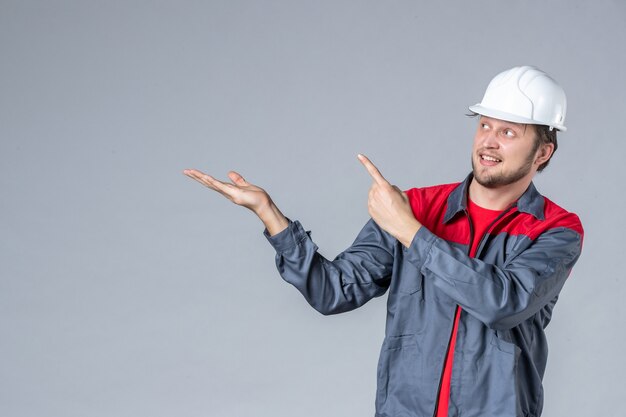 constructeur masculin vue de face en uniforme et casque sur fond gris