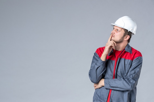 constructeur masculin vue de face en uniforme et casque sur fond gris