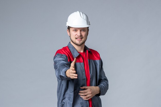 constructeur masculin vue de face en uniforme et casque sur fond gris