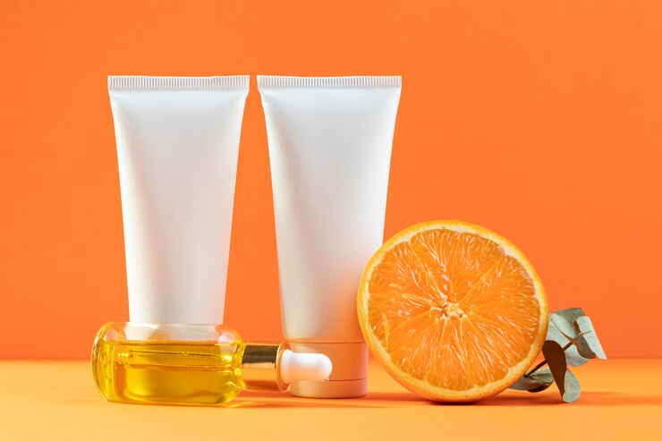Photo gratuit contenants de crème avec fond orange